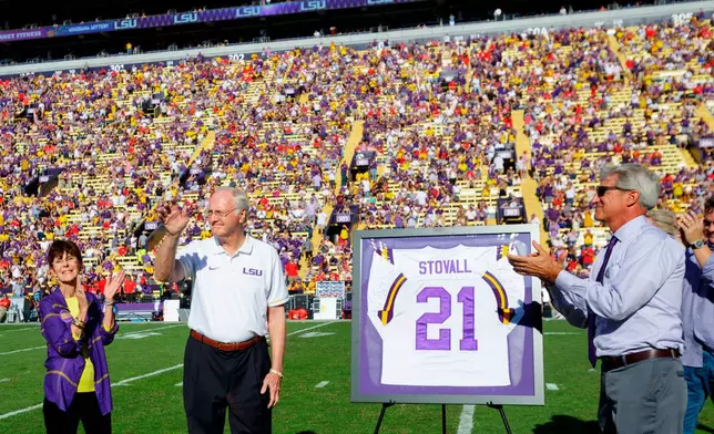 FILE - The number of LSU running back Jerry Stovall (21), second left, is retired in Tiger Stadium during halftime at an NCAA college football game between LSU and Georgia in Baton Rouge, La., Oct. 13, 2018. (AP Photo/Matthew Hinton, File)