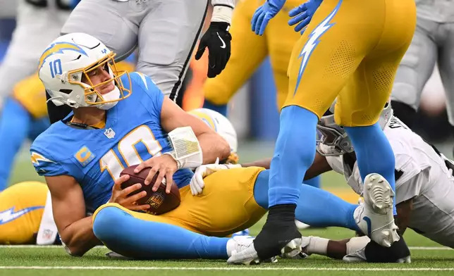 Los Angeles Chargers quarterback Justin Herbert (10) recovers a fumble during the second half of an NFL football game against the Las Vegas Raiders in Inglewood, Calif., Sunday, Sept. 20, 2026. (AP Photo/Katie Chin)
