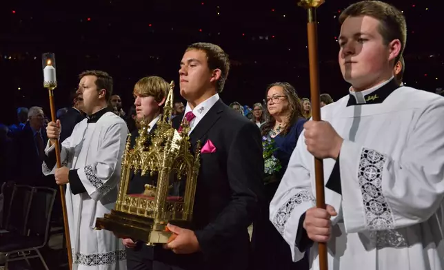 James Fulton Engstrom, center, his mother, Bonnie Engstrom, background center, and other family members present a relic of Archbishop Fulton Sheen during Sheen's beatification at the Dome at America's Center in St. Louis, on Thursday, Sept. 24, 2026. (AP Photo/Kate Munsch)