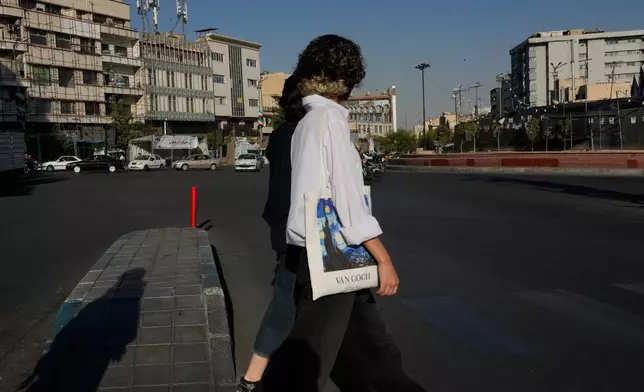 Women walk at the Islamic Revolution square in downtown Tehran, Tuesday, Sept. 15, 2026. (AP Photo/Vahid Salemi)