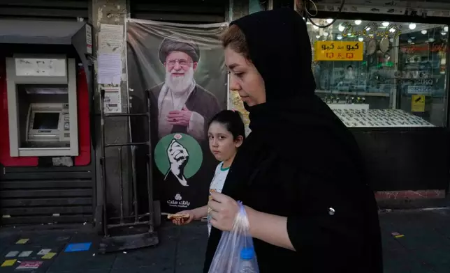 People pass a portrait of the late Iranian Supreme Leader Ayatollah Ali Khamenei, who was killed in the U.S and Israel strike on Feb. 28, at the Islamic Revolution square in Tehran, Tuesday, Sept. 15, 2026. (AP Photo/Vahid Salemi)