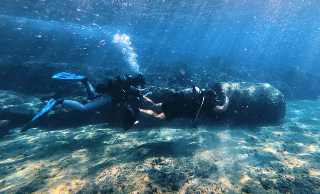 Manager of the Lebanon Diving Center Youssef Jundi, right, takes video of Roman-era columns at an archaeological site near the coast in the southern port city of Tyre, Lebanon, Thursday, Sept. 17, 2026. (AP Photo/Bilal Hussein)