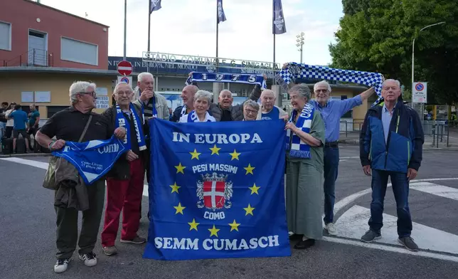 Como older fans pose in front of the stadium ahed of the Champions League opening phase soccer match between Como and Leipzig in Como, Italy, Thursday, Sept. 10, 2026, Como officials giving up seats to older fans. (AP Photo/Luca Bruno)