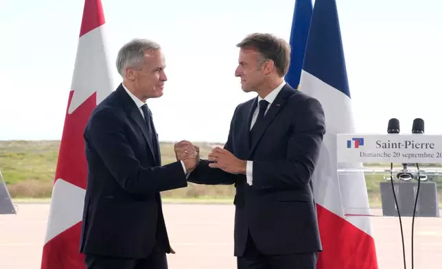 French President Emmanuel Macron, right, and Canadian Prime Minister Mark Carney embrace after delivering remarks in Saint-Pierre, Saint-Pierre-et-Miquelon, Sunday, Sept.20, 2026. (Adrian Wyld/The Canadian Press via AP)