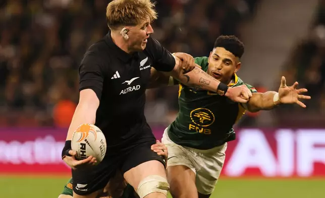 New Zealand's Fabian Holland, left, is tackled by South Africa's Sacha Feinberg-Mngomezulu, right, and his teammate during a second Test rugby match between South Africa and New Zealand, in Cape Town, South Africa, Saturday, Aug. 29, 2026. (AP Photo/Halden Krog)