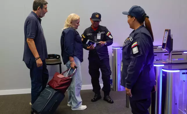 Departing passengers stand at security inside Simon Bolivar International Airport as it reopens to commercial flights two months after closing due to the earthquake in Maiquetia, Venezuela, Tuesday, Sept. 1, 2026. (AP Photo/Pedro Mattey)