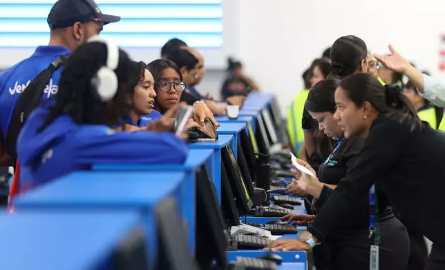 Passengers check in at Simon Bolivar International Airport as it reopens to commercial flights two months after closing due to the earthquake in Maiquetia, Venezuela, Tuesday, Sept. 1, 2026. (AP Photo/Pedro Mattey)