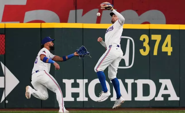Texas Rangers right fielder Brandon Nimmo, right, misplays the ball that allowed New York Mets' Francisco Alvarez to reach second and Carson Benge to score as center fielder Ezequiel Duran, left, looks on in the fourth inning of a baseball game Tuesday, Sept. 22, 2026, in Arlington, Texas. (AP Photo/Tony Gutierrez)