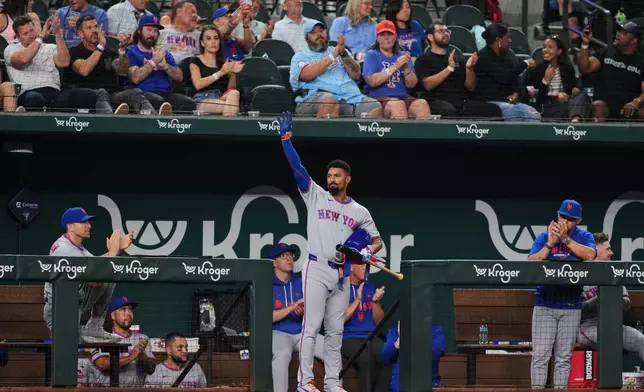 New York Mets' Marcus Semien acknowledges cheers from fans after a video tribute was played in honor of his time with the Texas Rangers in the second inning of a baseball game Tuesday, Sept. 22, 2026, in Arlington, Texas. (AP Photo/Tony Gutierrez)