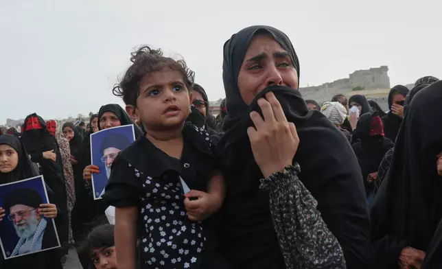 A woman carrying a child weeps during a mass funeral for people killed when, according to Iranian media and a rights group, a U.S. missile struck a home where a wedding was being held in Kuhestak, southern Iran, Thursday, Sept. 3, 2026. (Razieh Poudat/ISNA via AP)