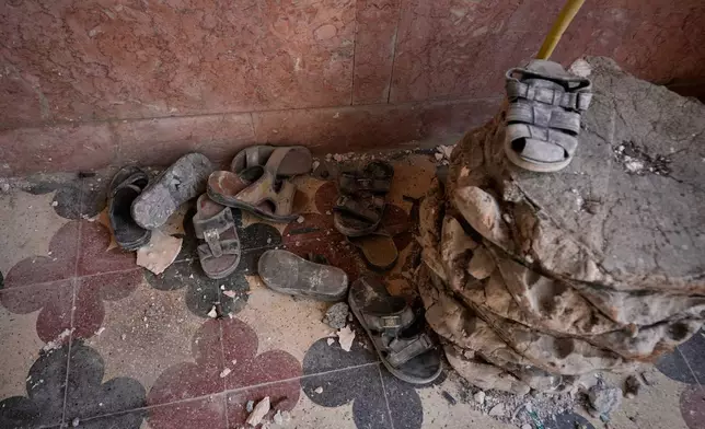 Dust-covered shoes lie amid debris inside a home that Iranian media said was hit by a U.S. strike while a wedding celebration was taking place late Tuesday, Sept. 1, in Kuhestak, southern Iran, Friday, Sept. 4, 2026. (AP Photo/Vahid Salemi)