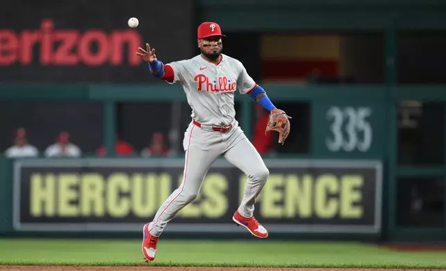 Philadelphia Phillies second baseman Luis Arraez tosses to first base to put out Washington Nationals' Abimelec Ortiz during the first inning of a baseball game, Wednesday, Sept. 16, 2026, in Washington. (AP Photo/Nick Wass)