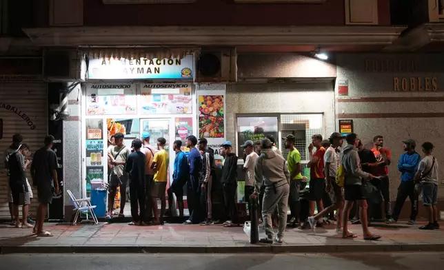 Migrants wait to buy food at a store in the Spanish exclave of Ceuta, Wednesday, Sept. 2, 2026. (AP Photo/Francis González)