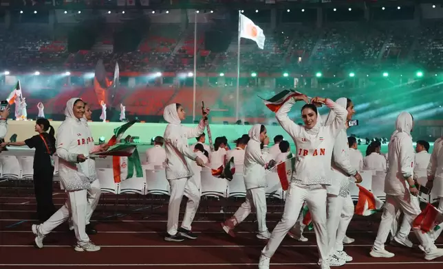 Iran athletes react as they march into the stadium during the opening ceremony for the Asian Games in Nagoya, Japan, Saturday, Sept. 19, 2026. (AP Photo/Lee Jin-man)