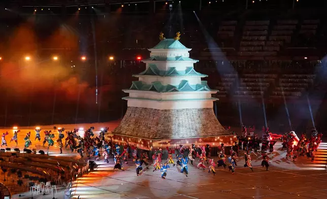 Dancers perform around a model of a Japanese castle during the opening ceremony for the Asian Games in Nagoya, Japan, Saturday, Sept. 19, 2026. (AP Photo/Dita Alangkara)