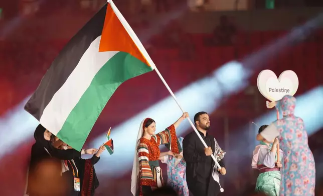 Palestinian flag bearers Farah Fares and Mohammed Hamada walk with teammates into the stadium during the opening ceremony for the Asian Games in Nagoya, Japan, Saturday, Sept. 19, 2026. (AP Photo/Lee Jin-man)