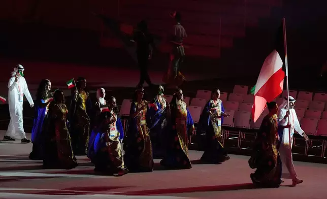 Kuwait's flag bearers Sarah Alhawal and Ebrahim Alzofairi and athletes walk into the stadium during the opening ceremony for the Asian Games in Nagoya, Japan, Saturday, Sept. 19, 2026. (AP Photo/Dita Alangkara)