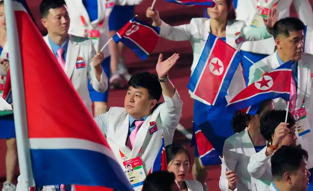 North Korean athletes react as they march into the stadium during the opening ceremony for the Asian Games in Nagoya, Japan, Saturday, Sept. 19, 2026. (AP Photo/Eugene Hoshiko)