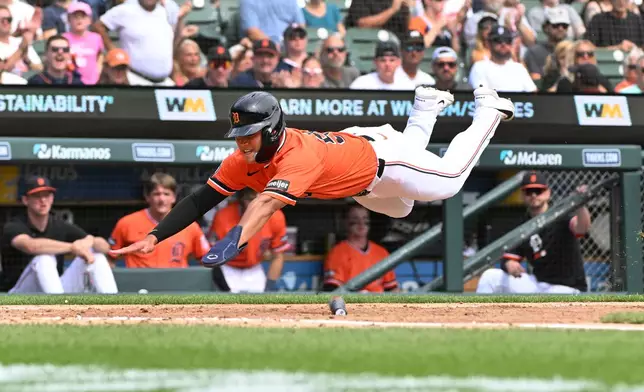 Detroit Tigers' Hao-Yu Lee dives towards home plate and scores a run during the fourth inning of a baseball game against the Colorado Rockies, Saturday, Sept. 12, 2026, in Detroit. (AP Photo/Jose Juarez)