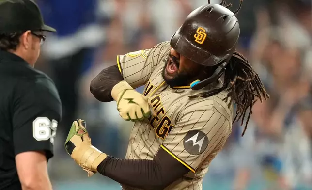 San Diego Padres' Fernando Tatis Jr. celebrates after scoring on a sacrifice fly by Manny Machado after Los Angeles Dodgers catcher Will Smith made a late tag during the fifth inning of a baseball game Wednesday, Sept. 23, 2026, in Los Angeles. (AP Photo/Mark J. Terrill)