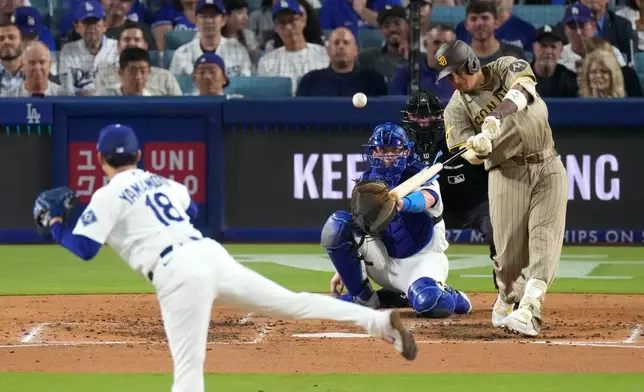 San Diego Padres' Manny Machado, right, hits a two-run home run as Los Angeles Dodgers starting pitcher Yoshinobu Yamamoto, left, and catcher Will Smith watch during the fourth inning of a baseball game Wednesday, Sept. 23, 2026, in Los Angeles. (AP Photo/Mark J. Terrill)