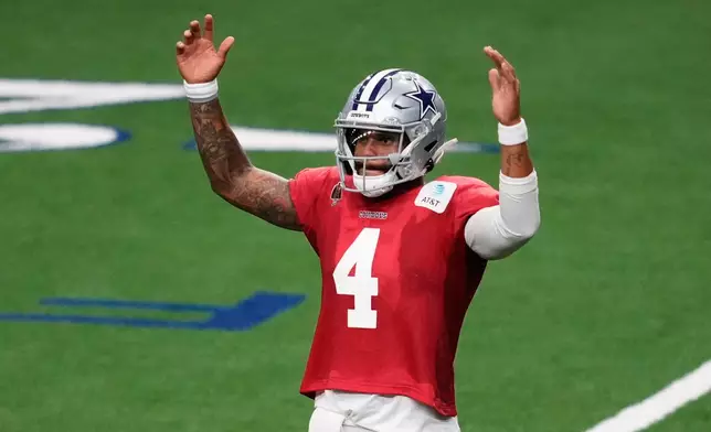 Dallas Cowboys quarterback Dak Prescott celebrates as the team run drills during an NFL football practice Wednesday, Aug. 26, 2026, in Frisco, Texas. (AP Photo/Tony Gutierrez)
