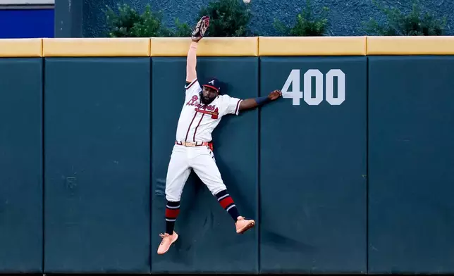 Atlanta Braves center fielder Michael Harris II misses catching a leadoff solo home run hit by Cincinnati Reds' Juan Brito during the first inning of a baseball game, Wednesday, Sept. 23, 2026, in Atlanta. (AP Photo/Erik S. Lesser)