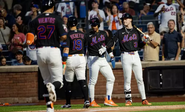 New York Mets players celebrate Mark Vientos' (27) three-run home run during the first inning of a baseball game against the San Francisco Giants, Friday, Sept. 4, 2026, in New York. (AP Photo/Angelina Katsanis)