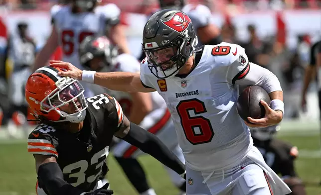Tampa Bay Buccaneers quarterback Baker Mayfield (6) scrambles for a first down as Cleveland Browns safety Ronnie Hickman (33) defends during the second half of an NFL football game in Tampa, Fla., Sunday, Sept. 20, 2026. (AP Photo/Jason Behnken)