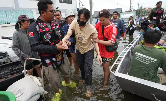 Rescuers evacuate a patient from a flooded area to a safer place in Bangkok, Thailand, Monday, Sept. 28, 2026. (AP Photo/Sakchai Lalit)