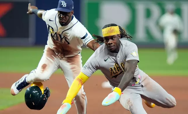 Athletics' Lawrence Butler, right, gets tagged out by Tampa Bay Rays shortstop Jorge Mateo after getting caught in a run down on a ground out by Donovan Walton during the fourth inning of a baseball game Wednesday, Sept. 16, 2026, in St. Petersburg, Fla. (AP Photo/Chris O'Meara)