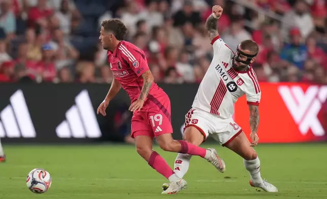 Toronto FC's Niklas Dorsch, right, challenges St. Louis City's Carlo Holse (19) for the ball during the first half of an MLS soccer match Saturday, Sept. 19, 2026, in St. Louis. (AP Photo/Jeff Roberson)