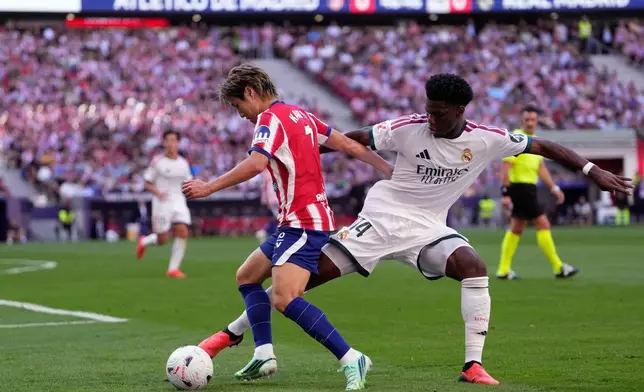Atletico Madrid's Lee Kang-in tries to dribble the ball past Real Madrid's Aurelien Tchouameni, right, during a Spanish La Liga soccer match between Atletico Madrid and Real Madrid in Madrid, Sunday, Sept. 20, 2026. (AP Photo/Bernat Armangue)