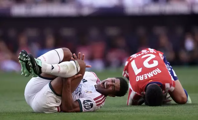 Real Madrid's Jude Bellingham and Atletico Madrid's Cristian Romero grimace on the ground after a collision during a Spanish La Liga soccer match between Atletico Madrid and Real Madrid in Madrid, Sunday, Sept. 20, 2026. (AP Photo/Bernat Armangue)