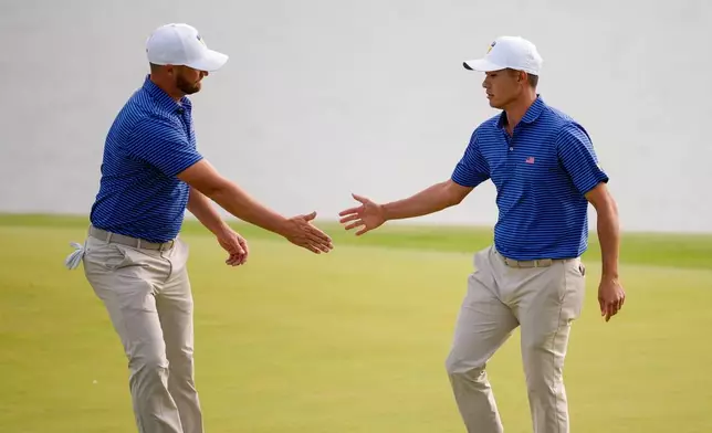 USA teams' Wyndham Clark, left, celebrates with Collin Morikawa on the 12th hole against the International team during the first round four-ball match at the Presidents Cup golf tournament at Medinah Country Club, Thursday, Sept. 24, 2026, in Medinah, Ill. (AP Photo/Matt Slocum)