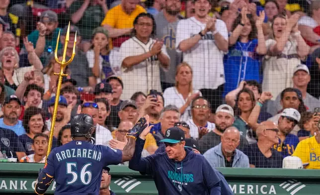 Fans applaud as Seattle Mariners' Randy Arozarena (56) is congratulated after his solo home run during the third inning of a baseball game against the Boston Red Sox, Monday, Aug. 31, 2026, in Boston. (AP Photo/Charles Krupa)