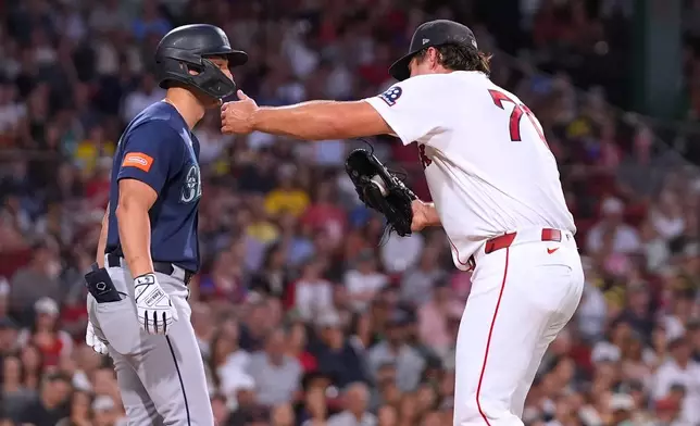 Boston Red Sox's Payton Tolle, right, hugs Seattle Mariners' Dominic Canzone , left, while making a force out on a ground ball during the third inning of a baseball game, Monday, Aug. 31, 2026, in Boston. (AP Photo/Charles Krupa)