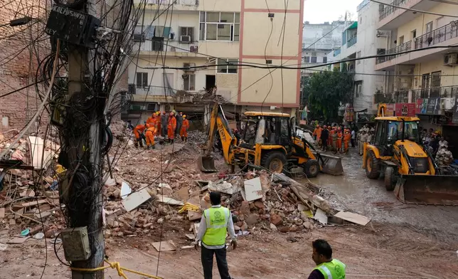 Rescuers clear debris as they search for people possibly trapped at the site of a collapsed building in New Delhi, India, Monday, Sept. 7, 2026. (AP Photo/Manish Swarup)