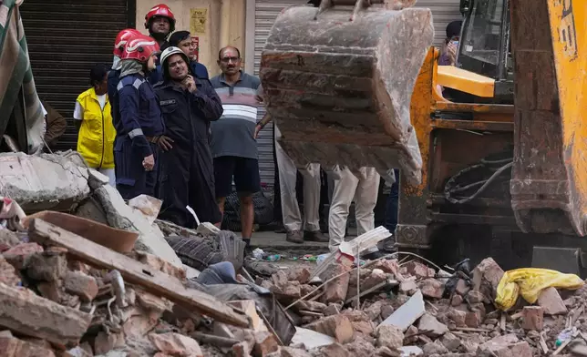 Rescuers clear debris as they search for people possibly trapped at the site of a collapsed building in New Delhi, India, Monday, Sept. 7, 2026. (AP Photo/Manish Swarup)