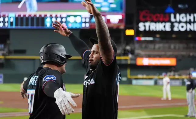 Miami Marlins' Jakob Marsee, left, celebrates his two-run home run against the Arizona Diamondbacks with Marlins' Deyvison De Los Santos during the third inning of a baseball game, Wednesday, Sept. 16, 2026, in Phoenix. (AP Photo/Ross D. Franklin)