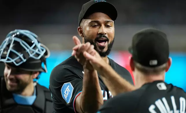 Miami Marlins pitcher Sandy Alcantara, left, celebrates a win against the Arizona Diamondbacks with Marlins manager Clayton McCullough after a baseball game, Wednesday, Sept. 16, 2026, in Phoenix. (AP Photo/Ross D. Franklin)