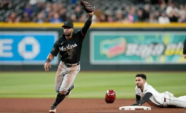 Miami Marlins shortstop Otto Lopez, left, celebrates after tagging out Arizona Diamondbacks' Jordan Lawlar during the ninth inning of a baseball game, Wednesday, Sept. 16, 2026, in Phoenix. (AP Photo/Ross D. Franklin)