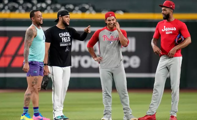 Returning Arizona Diamondbacks' Ketel Marte, left, talks with Diamondbacks' Eduardo Rodriguez, second from left, along with Philadelphia Phillies' Jesús Luzardo and Cristopher Sánchez, right, prior to a baseball game, Monday, Aug. 31, 2026, in Phoenix. (AP Photo/Ross D. Franklin)
