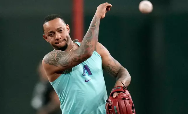 Returning Arizona Diamondbacks' Ketel Marte throws during infield practice prior to a baseball game against the Philadelphia Phillies, Monday, Aug. 31, 2026, in Phoenix. (AP Photo/Ross D. Franklin)