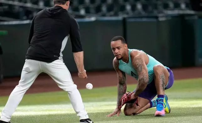 Returning Arizona Diamondbacks designated hitter Ketel Marte, right, fields grounders with Diamondbacks' Field Coordinator/Infield Coach Shaun Larkin prior to a baseball game against the Philadelphia Phillies, Monday, Aug. 31, 2026, in Phoenix. (AP Photo/Ross D. Franklin)