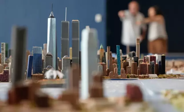 Lower Manhattan, featuring both the One World Trade and the Twin Towers, is seen on a large model of the New York City, made by Joe Macken, at the Museum of the City of New York in New York, Monday, Sept. 14, 2026. (AP Photo/Seth Wenig)