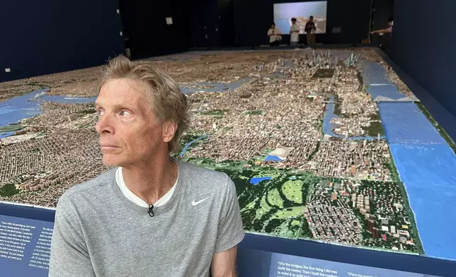 In this image taken with a smartphone=, truck driver Joe Macken poses in front of his scale model of New York City, Monday, Aug. 31, 2026, in New York. (AP Photo/Philip Marcelo)