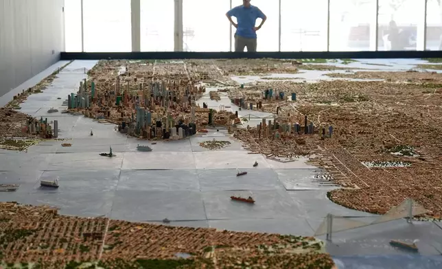 A visitor to the Museum of the City of New York looks over a model of New York City made by Joe Macken in New York, Monday, Sept. 14, 2026. (AP Photo/Seth Wenig)