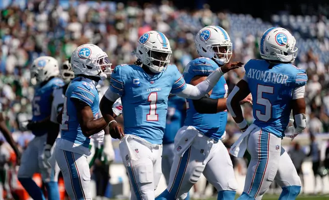 Tennessee Titans quarterback Cam Ward (1) congratulates wide receiver Elic Ayomanor (5) after he scored a touchdown during the second half of an NFL football game against the New York Jets, Sunday, Sept. 13, 2026, in Nashville, Tenn. (AP Photo/George Walker IV)