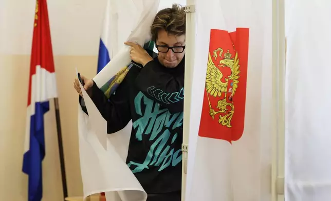 A woman leaves a voting booth to cast her ballot in the parliamentary election in Vladivostok, Russia, Friday, Sept. 18, 2026. (AP Photo)